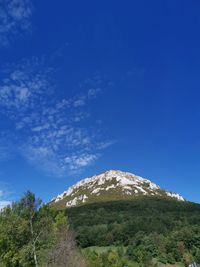 Low angle view of mountain against blue sky