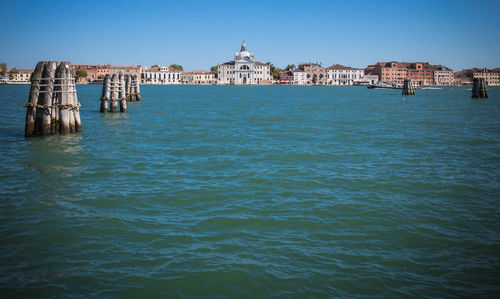 View of sea by buildings against clear blue sky in venice 