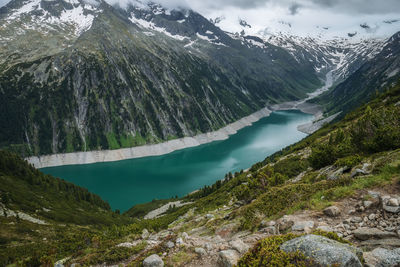 Scenic view of lake by mountains during winter