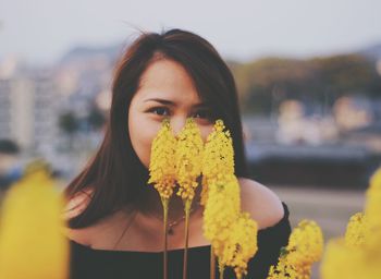 Portrait of woman holding yellow flowers