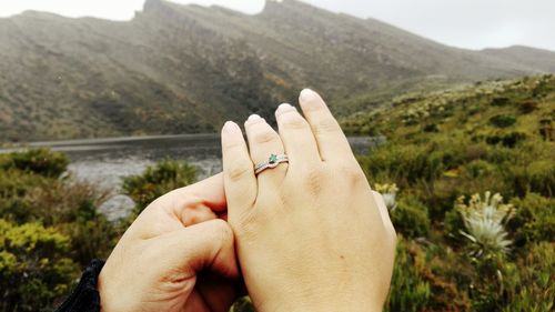 Cropped hands of couple on mountain