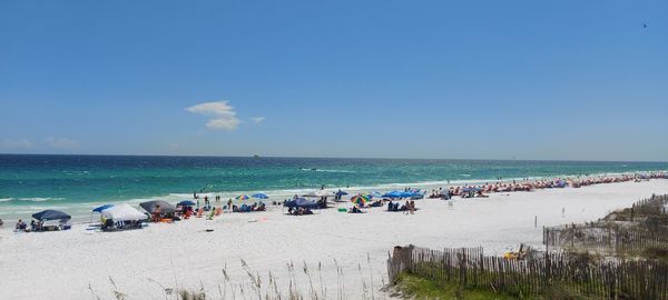 Group of people on beach against sky