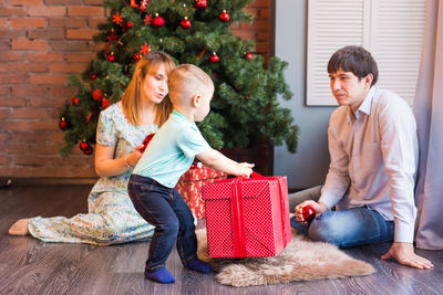 Full length of mother and girl with christmas tree