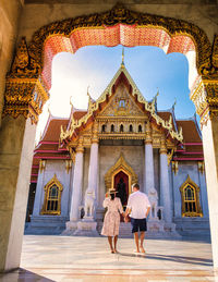 Rear view of woman standing outside temple