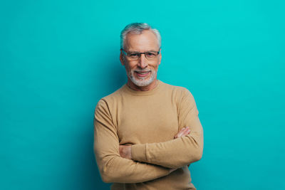 Portrait of smiling man against blue background