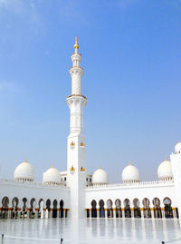 Low angle view of mosque against clear blue sky