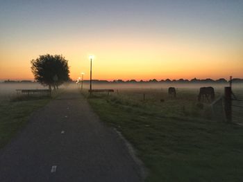 Scenic view of field against clear sky during sunset