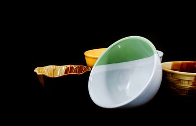 Close-up of drink in bowl on table against black background