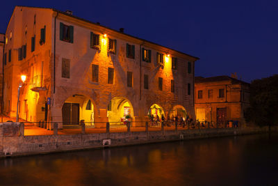 Restaurant terrace at the riverside in the night . street terrace at sile river in treviso . 