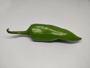 Close-up of green chili pepper against white background