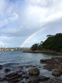 Scenic view of rainbow over sea against sky