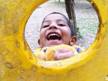 Portrait of playful boy seen through play equipment