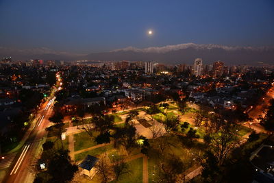 High angle view of illuminated cityscape against sky at night