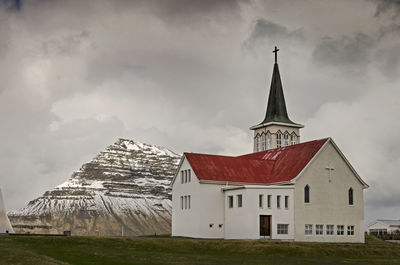 The town's church with in the background the iconic kirkjufell under a cloudy sky