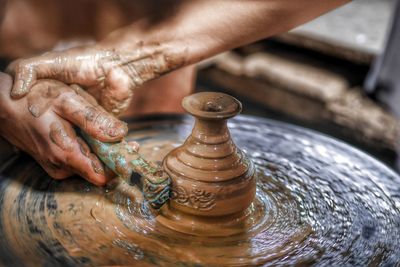 Midsection of man designing pot