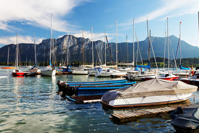 Boats moored at harbor against sky