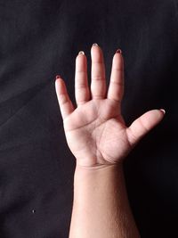 Close-up of person hand against black background