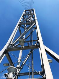 Low angle view of crane against clear blue sky