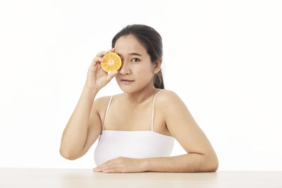 Portrait of young woman against white background