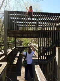 Woman standing on wooden railing