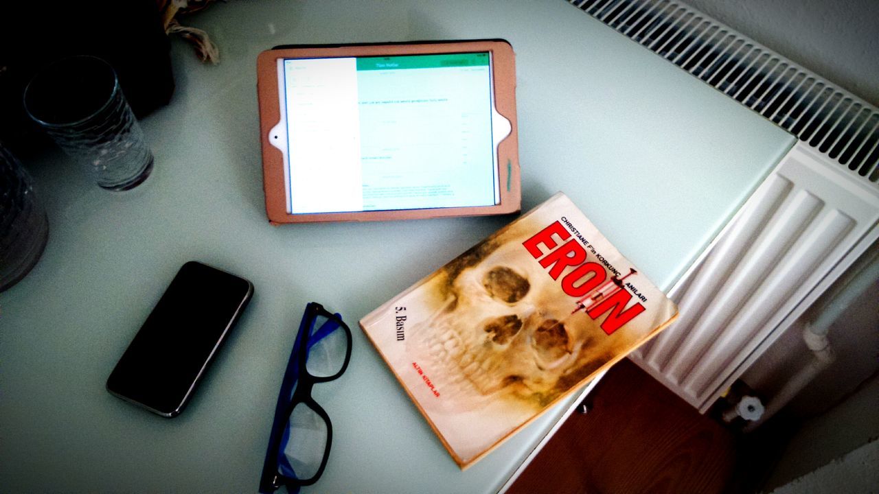 indoors, table, still life, communication, book, high angle view, technology, paper, close-up, education, desk, laptop, wireless technology, text, no people, computer, connection, home interior, western script, absence