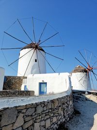 Low angle view of windmills against clear sky