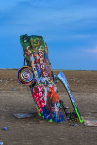 Graffiti on wall by sea against sky