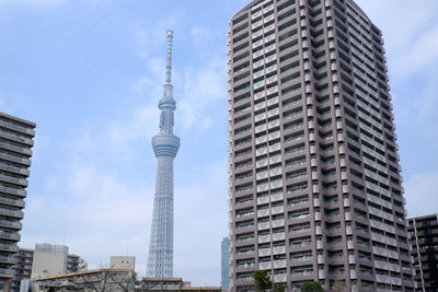 Low angle view of buildings against cloudy sky