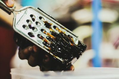 Cropped hand grating food in kitchen