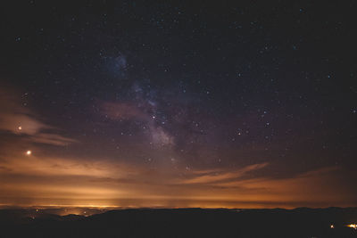 Scenic view of silhouette mountain against sky at night