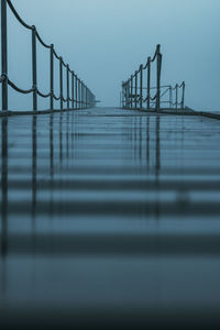 Surface level of pier over sea against clear sky