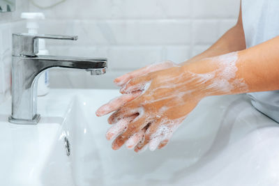 Midsection of woman in bathroom at home