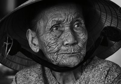 Close-up of senior woman wearing asian style conical hat