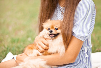 Portrait of woman with dog on grass