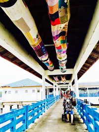 Low section of woman standing on multi colored umbrella