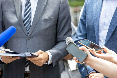 Midsection of man using mobile phone