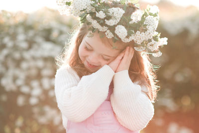 Portrait of young woman standing against plants