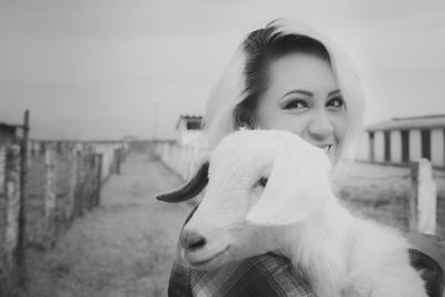 Portrait of woman with dog against sky
