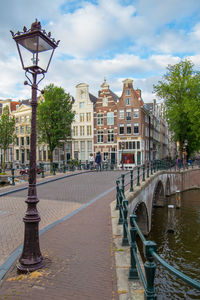 Street by buildings against sky in city