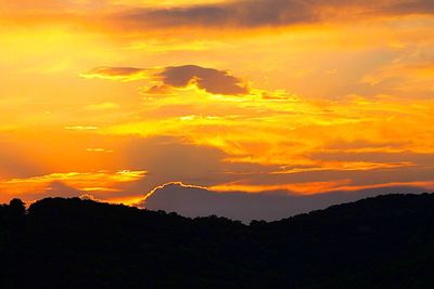 Silhouette of mountain against dramatic sky