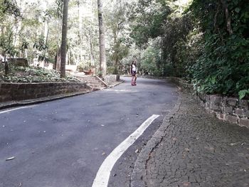 Woman riding bicycle on road in city