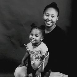 Portrait of smiling girl against gray background