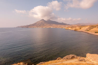 Scenic view of sea and mountains against sky