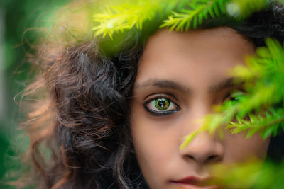 Close-up portrait of young woman by plants