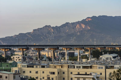 Bridge over buildings in city against sky