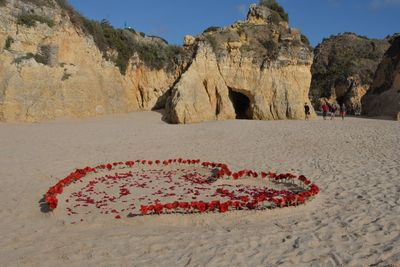 Corazón de flores en la arena después de reportajes de boda en portugal