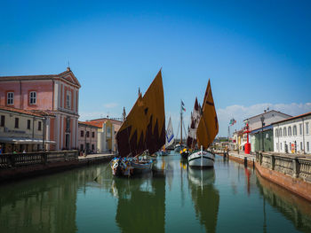 View of canal amidst buildings against sky