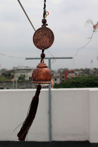 Close-up of chain hanging against sky