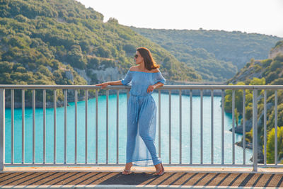 Woman standing near railing on footbridge