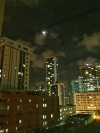 Illuminated buildings against sky at night